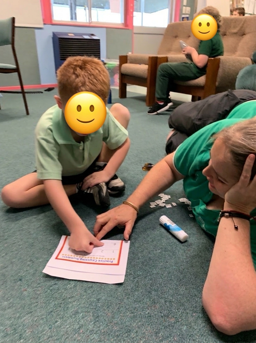 Natalie working one-on-one with a child on the floor